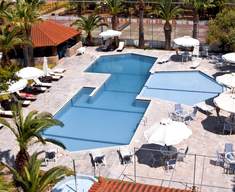 爱琴娜岛克罗诺斯安娜酒店的享有带遮阳伞和椅子的游泳池的顶部景致
