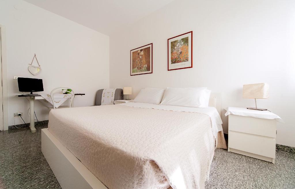 塔兰托B&B Magna Grecia di Gallitelli的白色卧室配有白色的床和电视