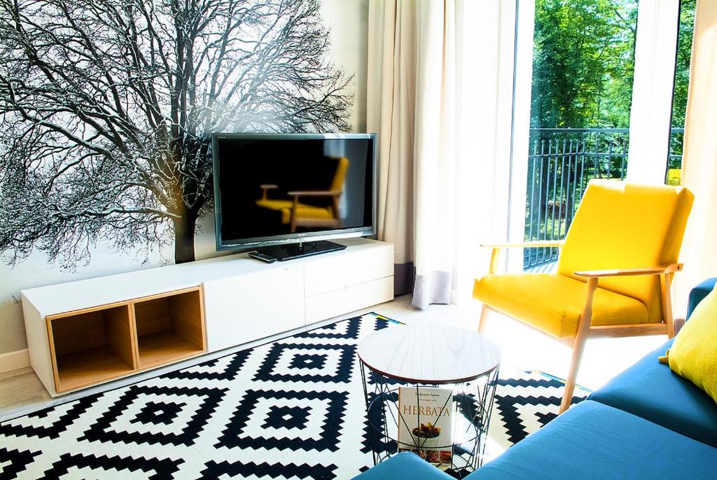 格鲁德柴兹Apartament 4 You的客厅配有电视和黄色椅子