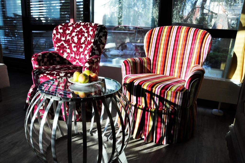 斯图加特科雷尔林德餐厅酒店的两张椅子和一张桌子,上面放着一碗水果