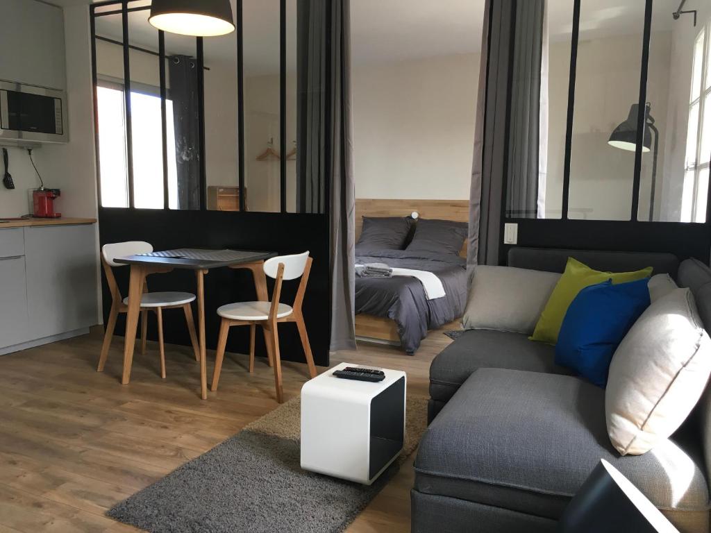 拉罗谢尔Appartements Les Rochelais的客厅配有沙发、桌子和床。