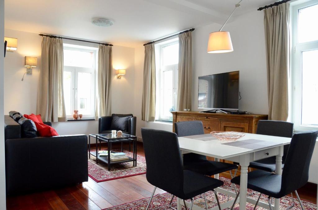 斯塔沃洛Le Baron Apartments的客厅配有白色的桌子和椅子