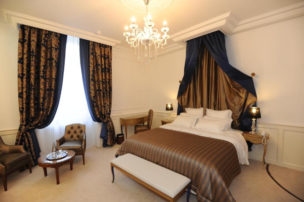 蓬托尔松Hôtel Victor Hugo的酒店客房,配有一张床和吊灯