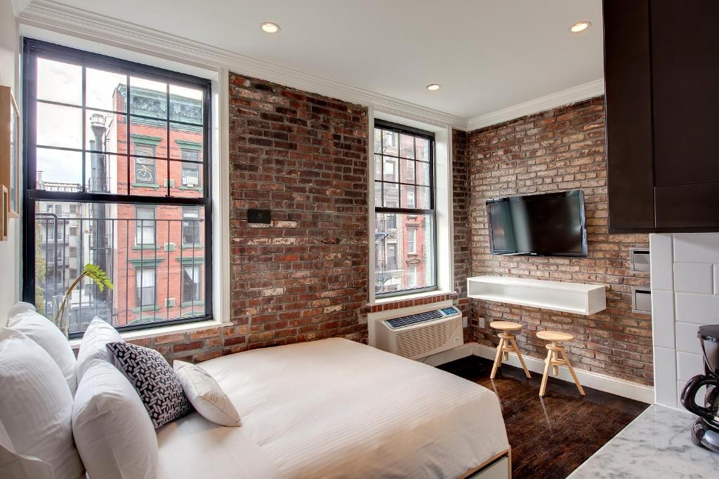 纽约东乡村酒店的卧室设有砖墙、床和窗户