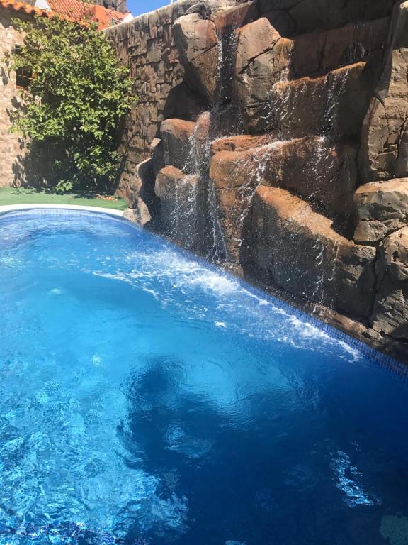 法塔加加那利伊利莎酒店的石墙旁的瀑布游泳池
