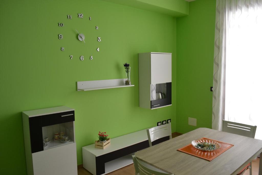 苏尔博b&b Appia Antica的绿色的用餐室,墙上设有桌子和时钟