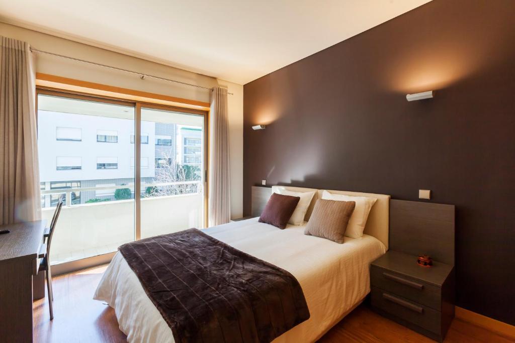 波尔图Onice Apartment的一间卧室设有一张大床和一个大窗户