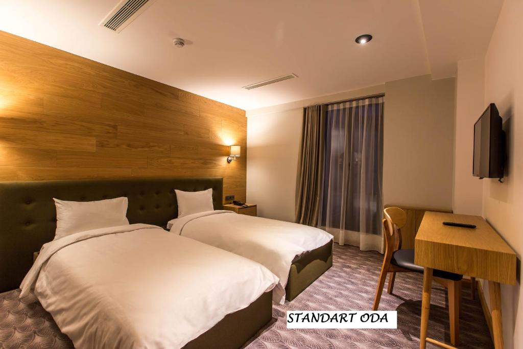 AvdancıkAbant Lotus Otel的酒店客房配有两张床和一张书桌