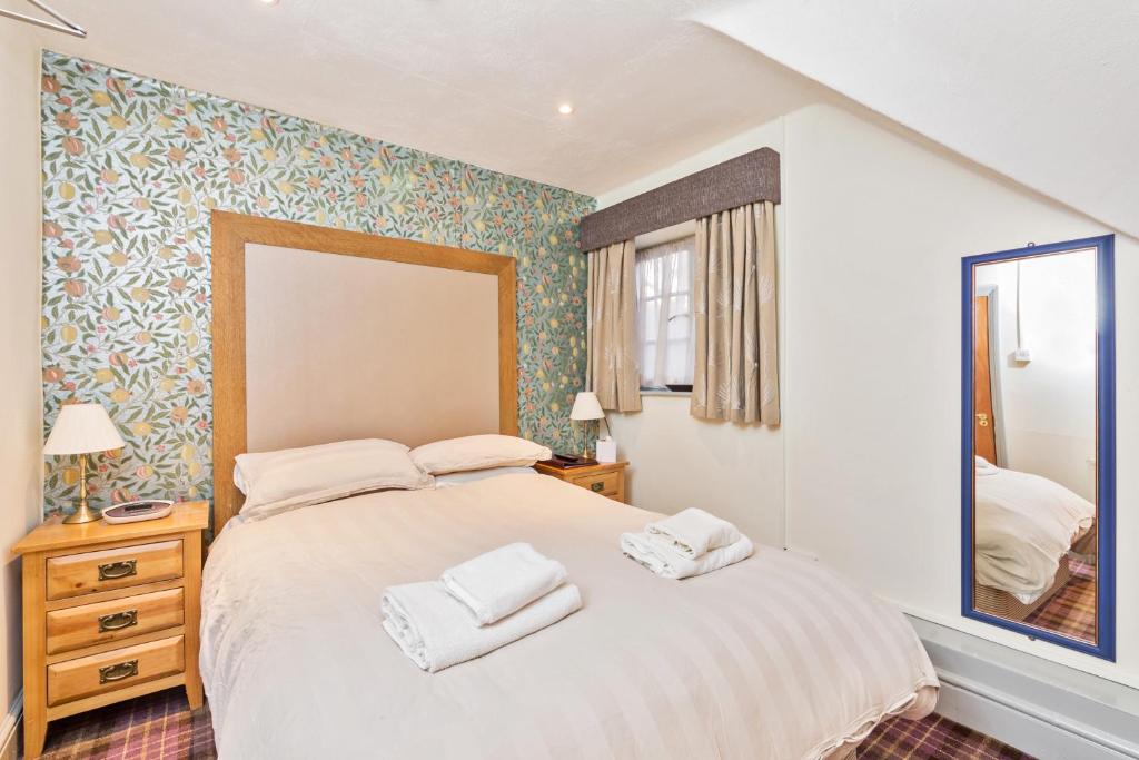 水上伯顿惠灵顿公爵旅馆的一间卧室配有一张大床和两条毛巾