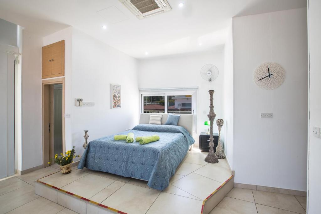 普罗塔拉斯帕利尼庭院公寓的一间白色客房内的蓝色床卧室