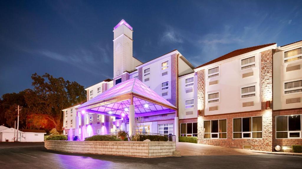 桑达斯基贝斯特韦斯特桑达斯基套房酒店的塔楼前有紫色照明的建筑