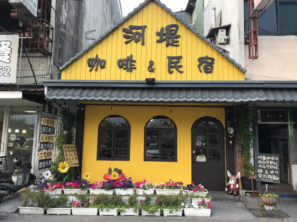 水里乡水里河堤咖啡民宿 Shuili Heti coffee B&B的黄色的建筑,有亚洲的书写
