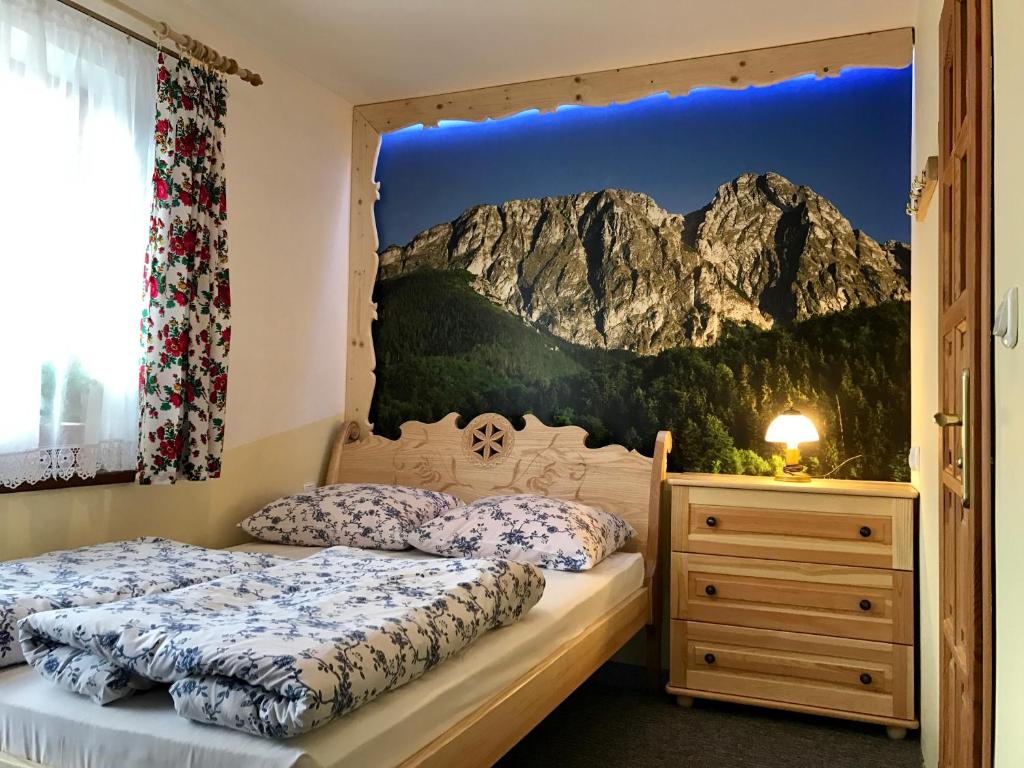 扎科帕内Chatka U Hazy - Regionalne Pokoje Zakopane的卧室内的两张床,墙上挂着山壁画