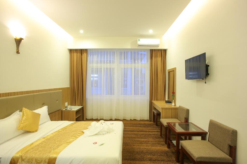 岘港红宫酒店的酒店客房配有一张床、一张书桌和一台电视。