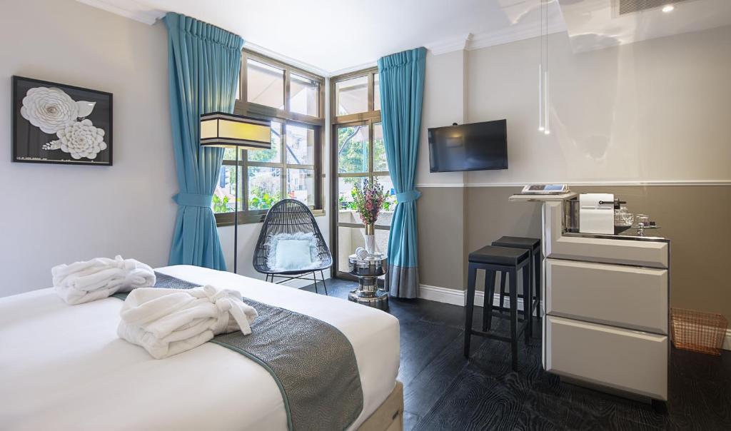 特拉维夫A23精品酒店 的一间卧室配有一张床、一张书桌和一个窗户。