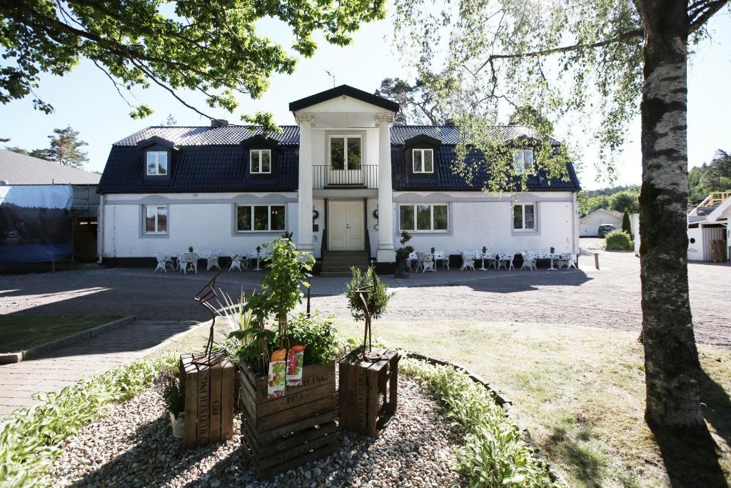 莫伦莱克Hällsnäs Hotell & Restaurang的黑色屋顶的大型白色房屋