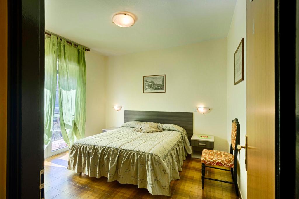奥斯塔曼库索维尔森酒店的一间卧室设有一张床、一个窗口和一把椅子
