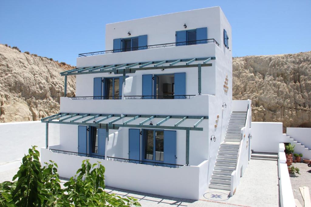 阿彻奇洛斯Pontoria Stegna Studios的白色的房子,设有蓝色的门和窗子