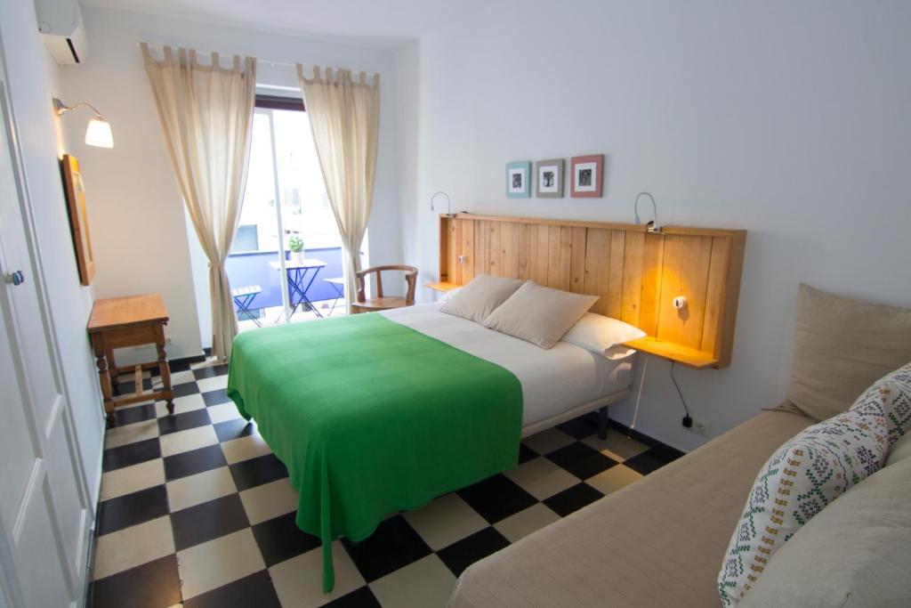 马贝拉芬兰蒂亚酒店的一间卧室配有一张带绿毯的床