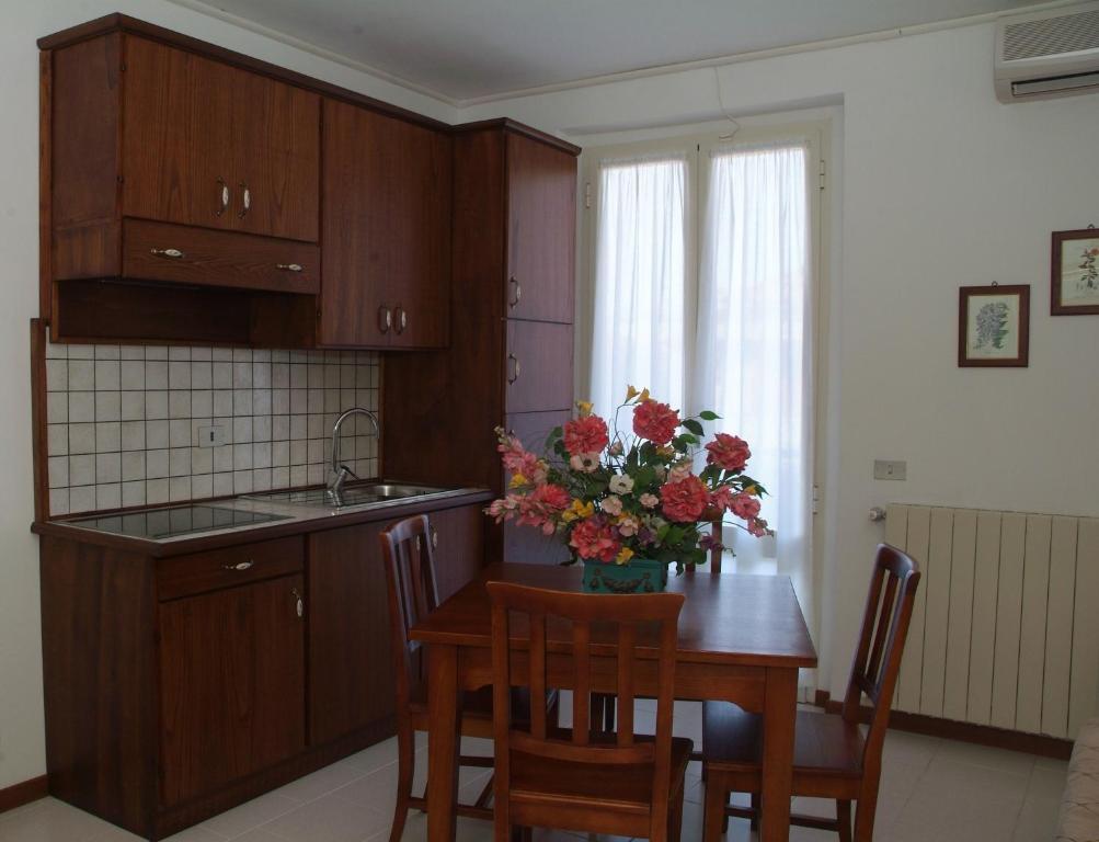 格罗塞托港卡夫普里斯科公寓的厨房配有一张桌子,上面放着花瓶