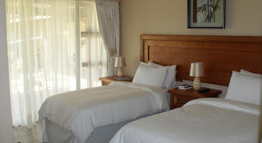 丹地Mountain View Guest House的酒店客房设有两张床和窗户。
