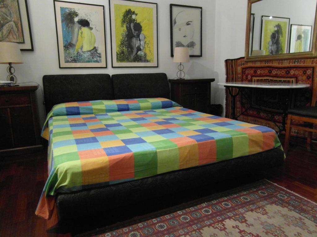 罗马阿比塔兹纳皮吉纳托住宿加早餐酒店的一张床上,床上有五彩缤纷的毯子