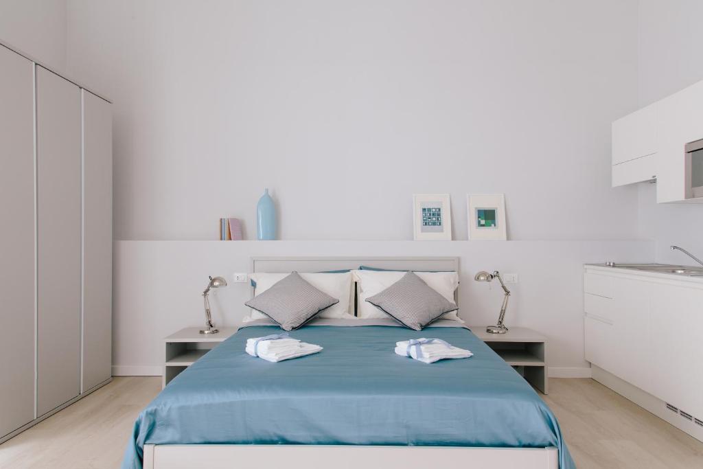 特拉尼Trani Rent Rooms的白色卧室配有蓝色的床和2个枕头