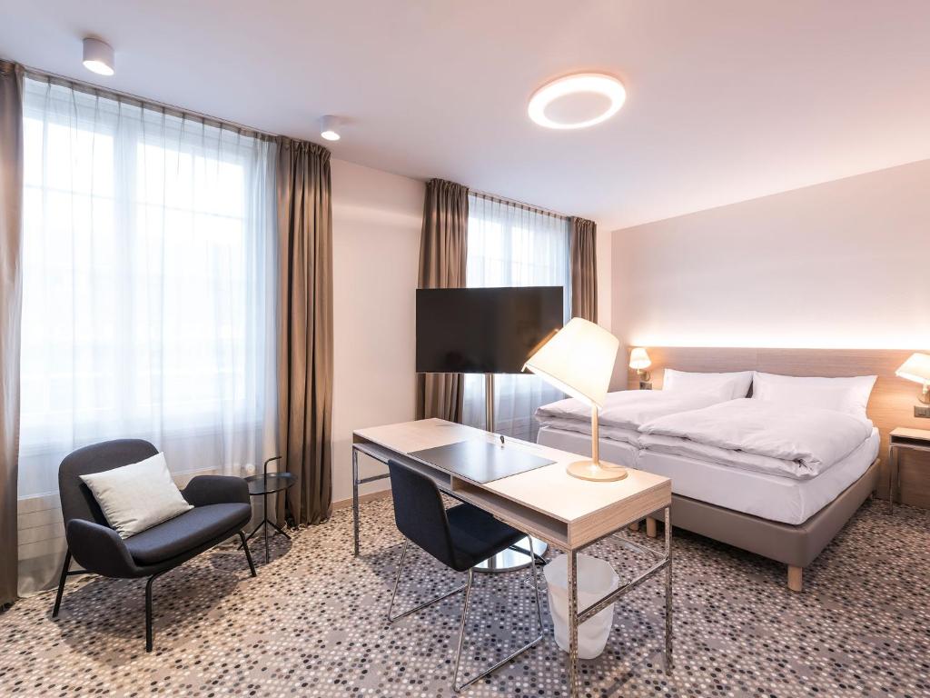 伯尔尼萨沃伊酒店的酒店客房配有一张床、一张桌子和一把椅子。