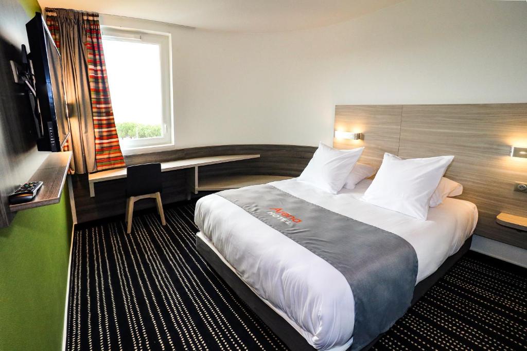 图卢兹图卢兹体育场酒店的酒店客房设有一张大床和一张书桌。
