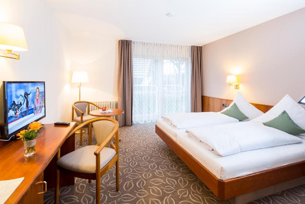 巴特瓦尔德塞阿德尔酒店的配有一张床和一张书桌的酒店客房
