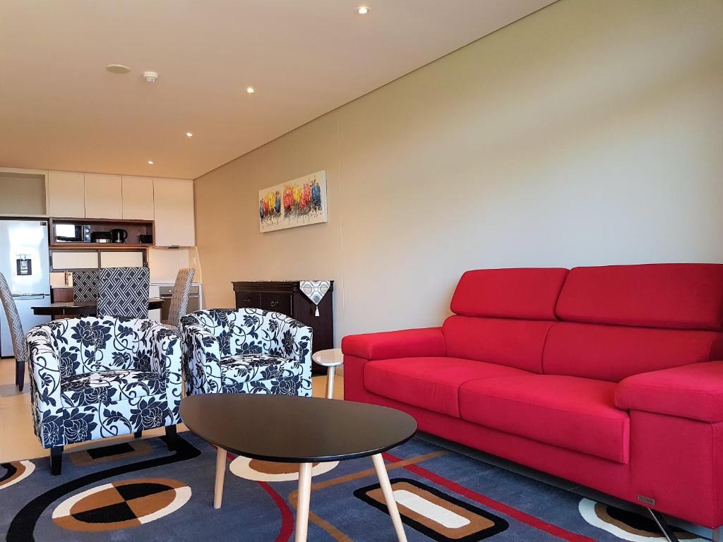 巴利托Zimbali Suites 301的客厅配有红色的沙发和椅子