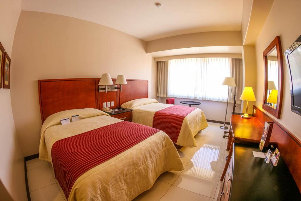 瓦哈卡市福廷广场酒店的酒店客房设有两张床和窗户。