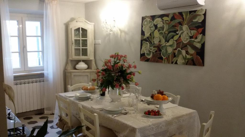 卢卡Luxury apartment Suite La Fontana的餐桌,配有白色桌布和鲜花