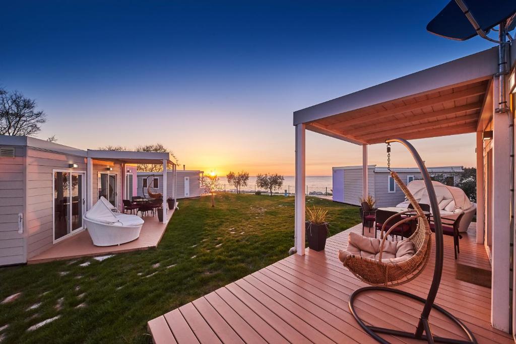 乌马格Mobile Homes Sunset Beach的房屋内带吊床和椅子的甲板