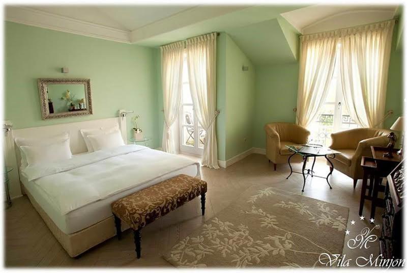 弗尔尼亚奇卡矿泉镇敏荣豪华客房住宿加早餐旅馆的一间卧室配有一张床、一把椅子和一张桌子