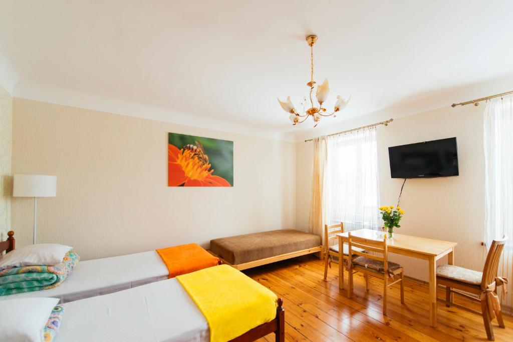 利耶帕亚曼丹尼公寓的一间卧室配有一张床、一张桌子和一张沙发