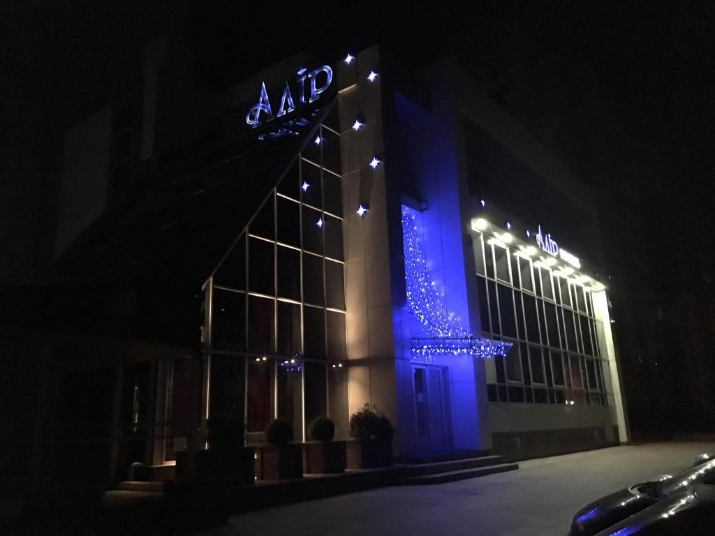日托米尔艾里尔酒店的一座大建筑,晚上有蓝色的灯光