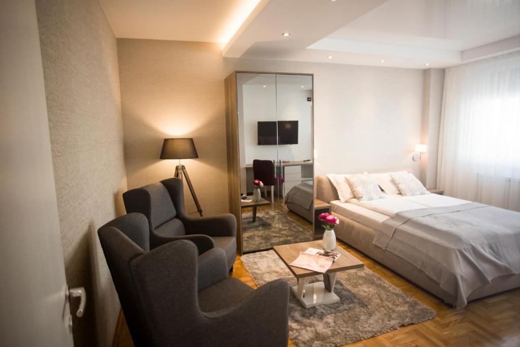 贝尔格莱德Dia Belgrade Arena Apartment的酒店客房,配有一张床和两把椅子
