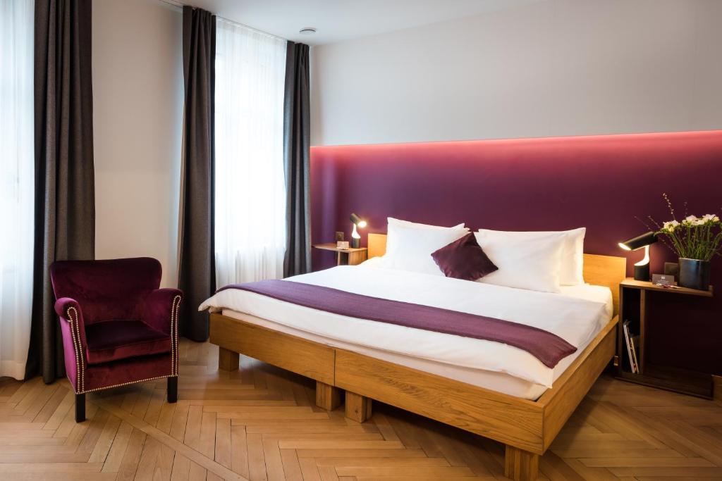 苏黎世尼莫精品酒店的一间卧室设有一张大床和红色床头板