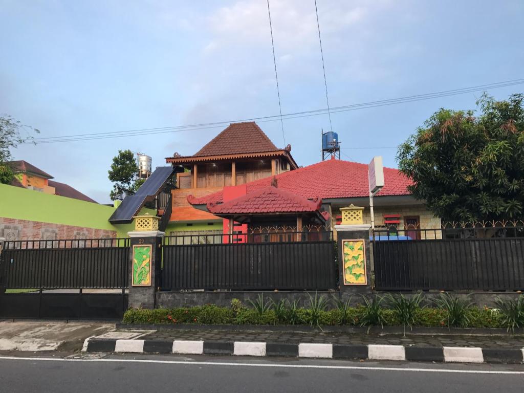 日惹Jogja Classic Homestay Syariah的一座红色屋顶和黑色围栏的房子