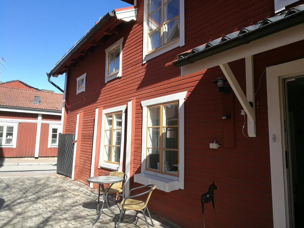 法伦Kopparstugans Bed & Breakfast的一间红色的房子,前面有椅子和桌子