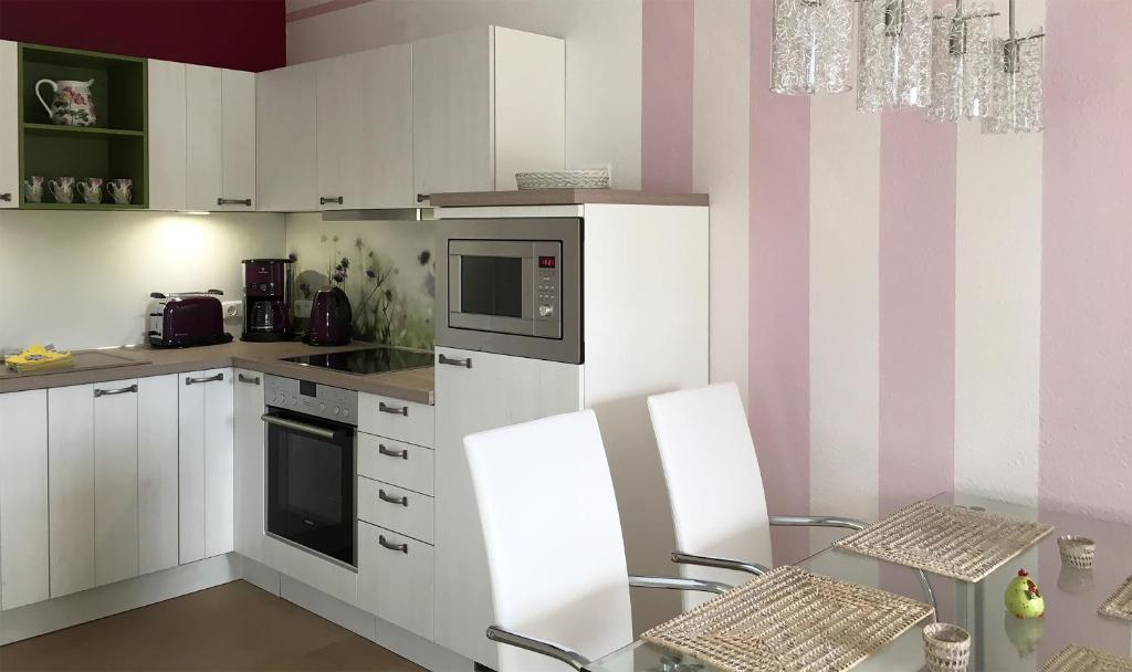 普雷罗浪漫风情公寓的厨房配有白色家电和粉色及白色条纹