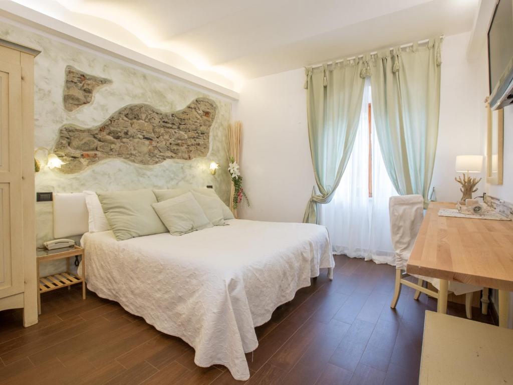 蒙特罗索阿尔马雷玛瑞娜酒店的卧室配有一张白色的大床和一张桌子