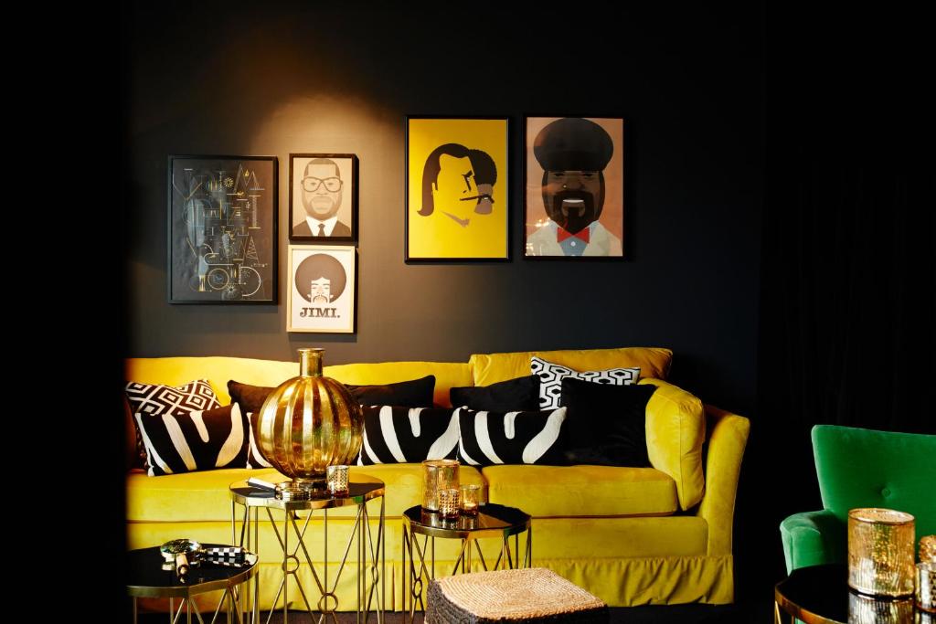 科隆朋友酒店的客厅配有黄色沙发和墙上的照片