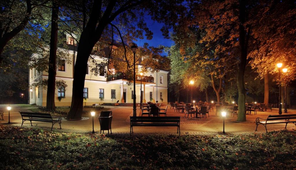 RybnaPalac w Rybnej的夜间公园,设有长凳和桌子及灯