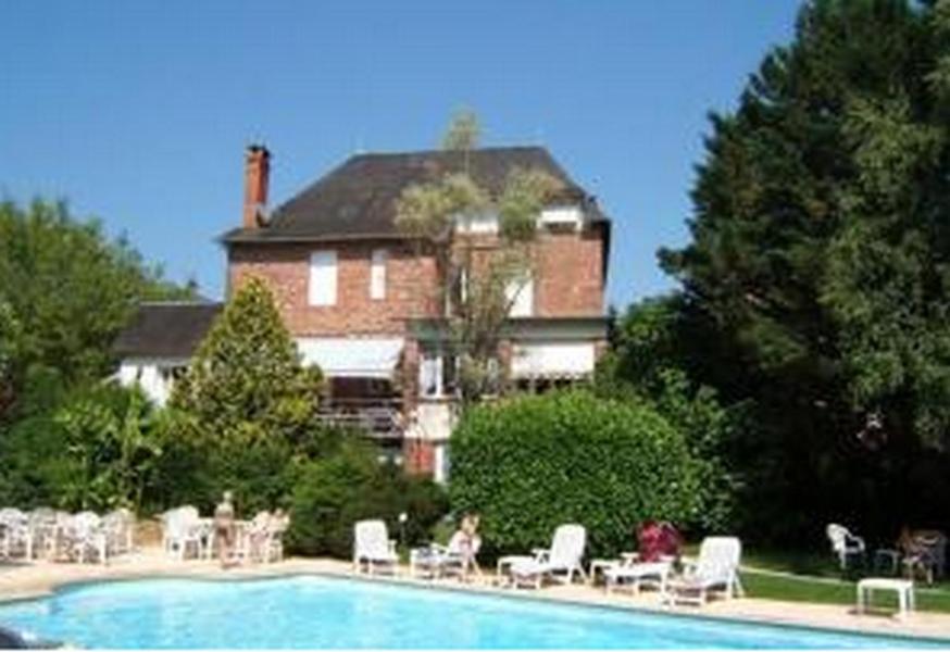 MeyssacLogisHotels Le Relais du Quercy的一座大房子,房子前面设有一个游泳池