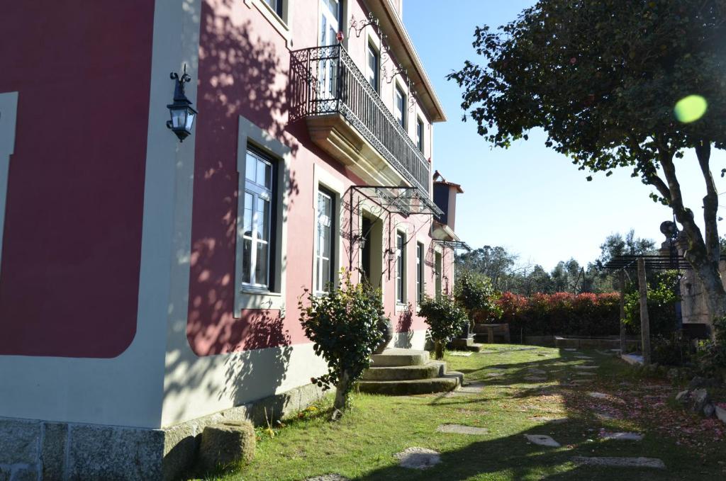 AncedeSolar da Motta Douro Boutique Home的一座粉红色的建筑,其一侧设有阳台
