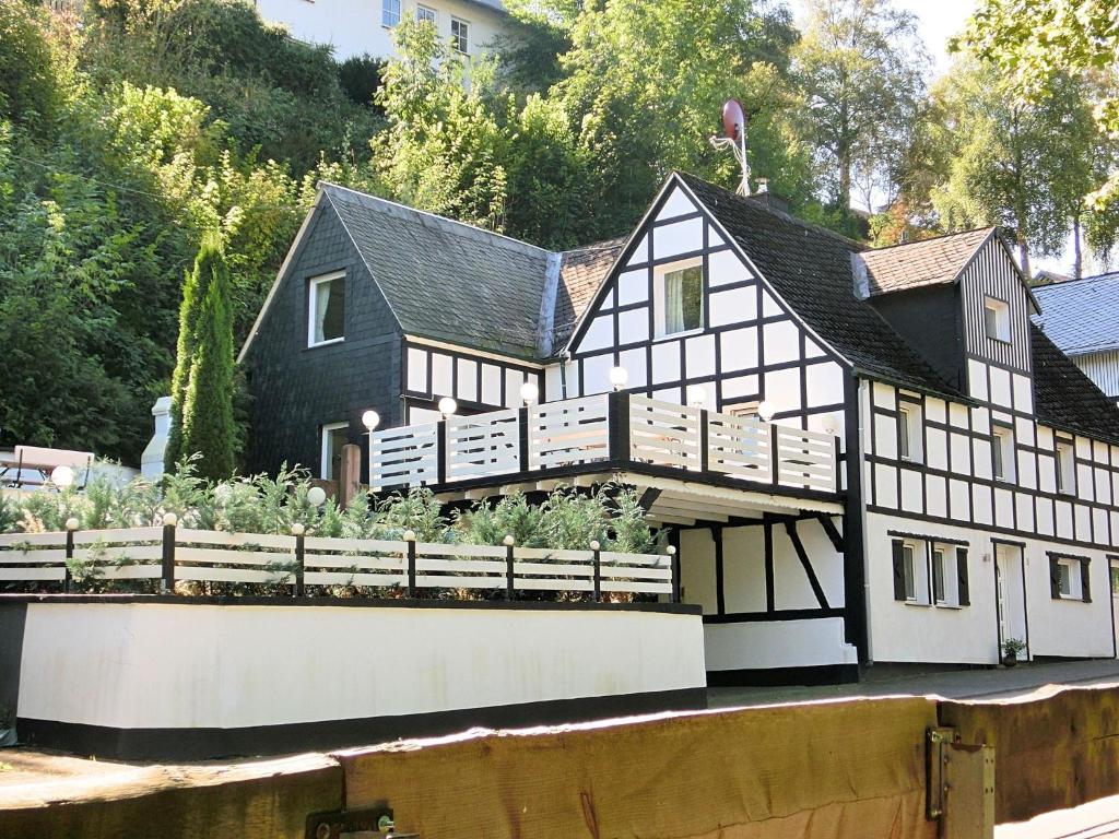 施马伦贝格Charming holiday home near the ski area的一座黑白房子,前面有一个花园