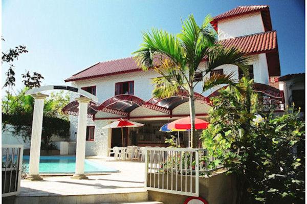 弗洛里亚诺波利斯索尔玛德佛洛瑞拉住宅酒店的一座房子,前面有一座游泳池和一棵棕榈树