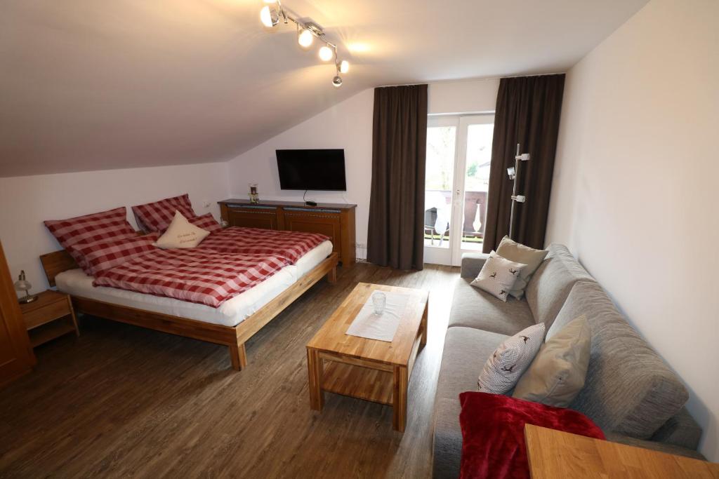 加尔米施-帕滕基兴Alpen - Apartments的客厅配有床和沙发